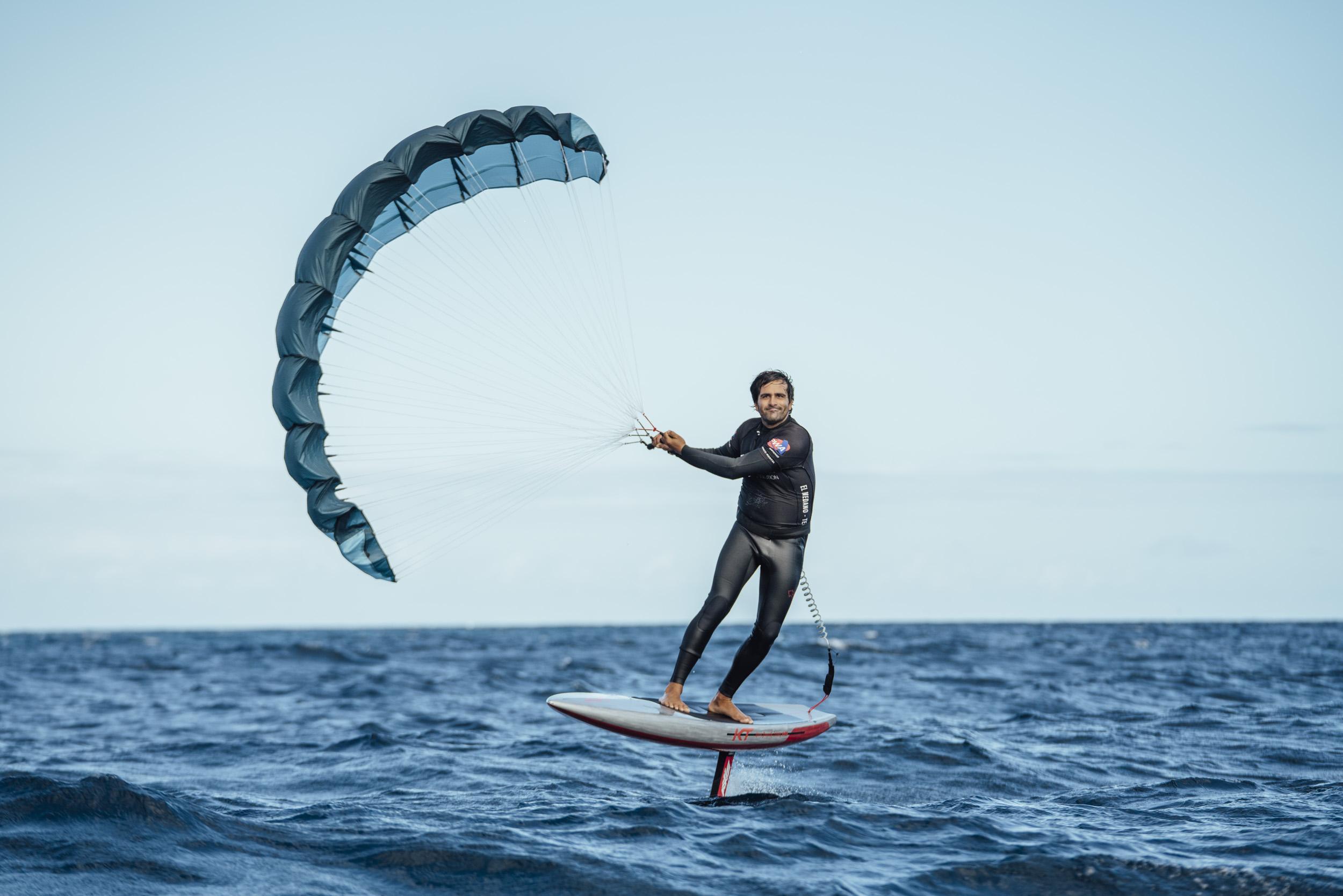 Aeryn P1 rider foiling with wing in low arc, second rider visible in the background on open ocean
