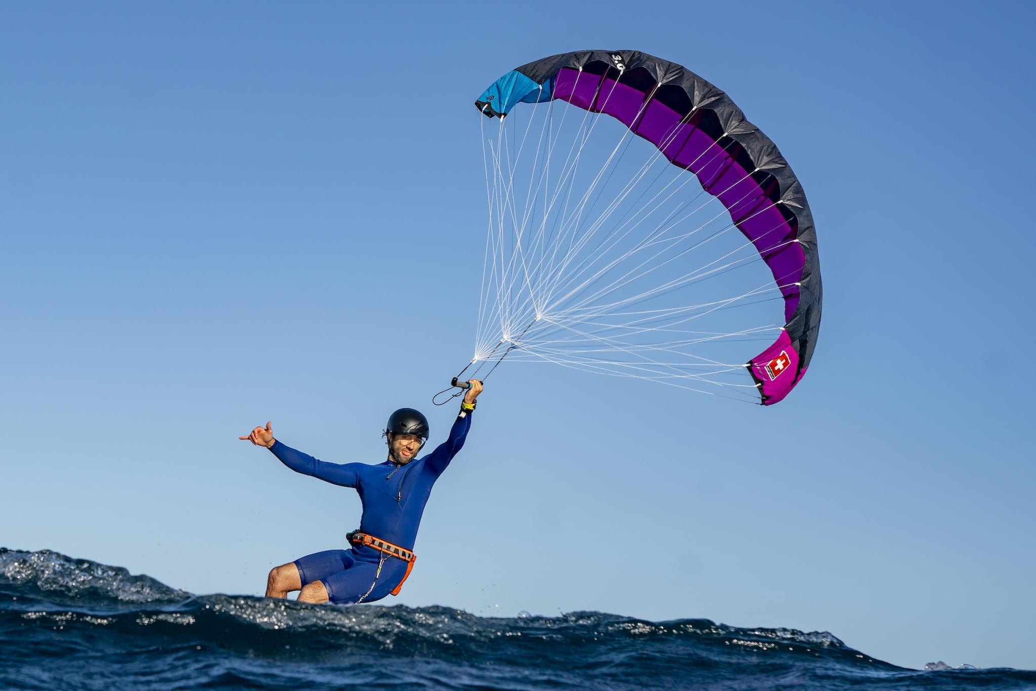 Ensis Roger rider downwinding with purple wing deployed, expressive low-angle action shot