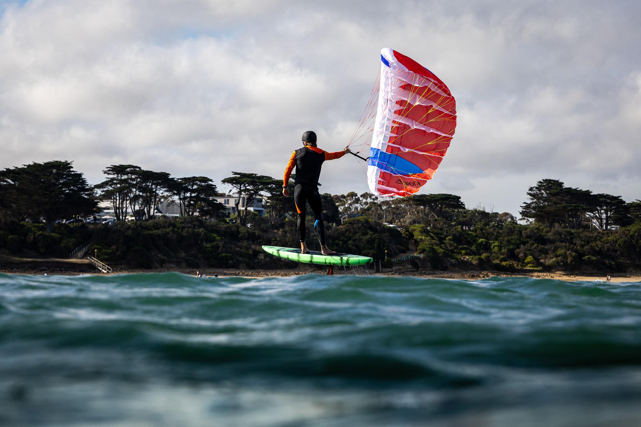 Flow D-Wing rider foiling along the Australian coast with the wing in a clean arc