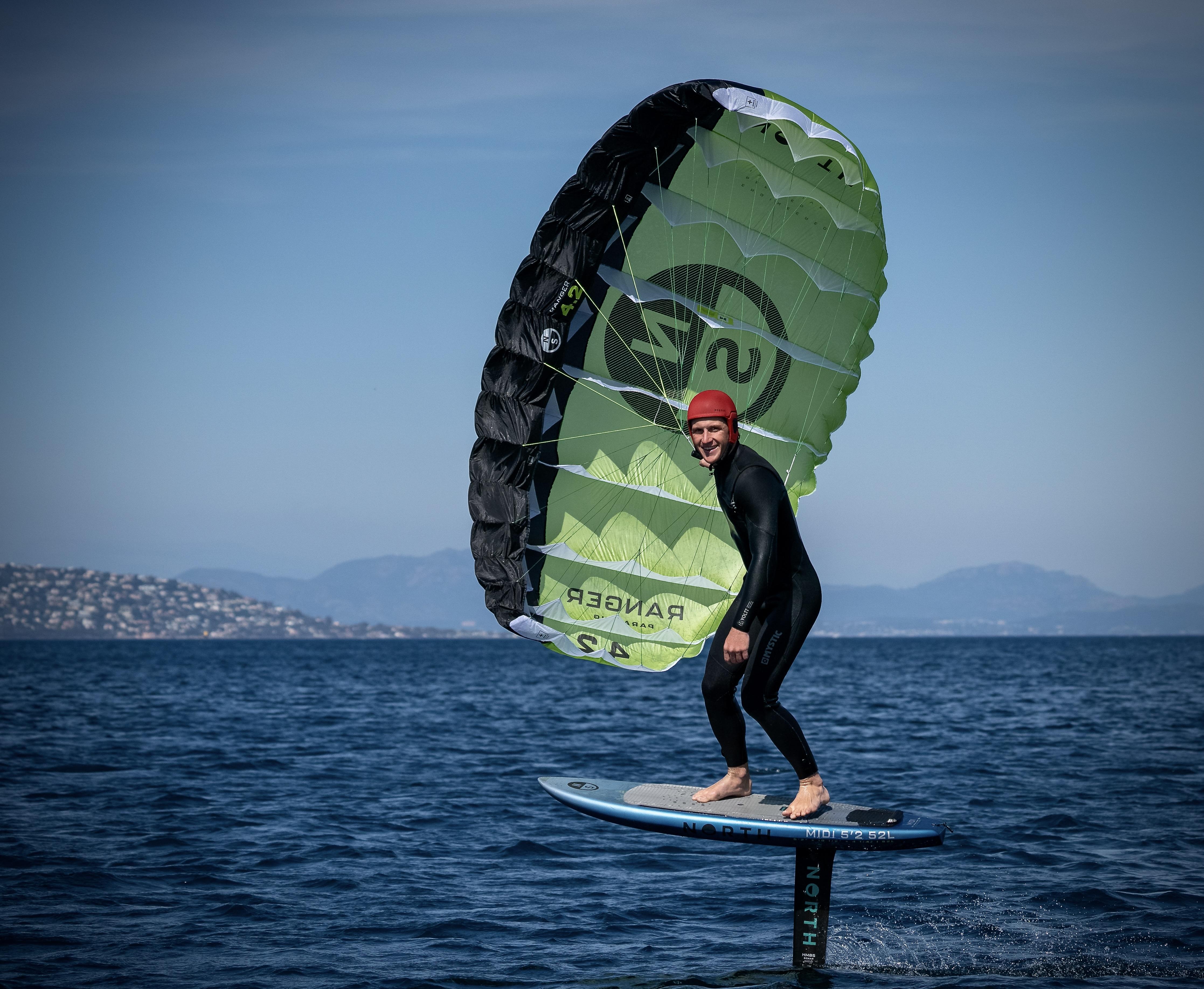 North Ranger parawing rider smiling while foiling, showing the compact wing shape and clear branding