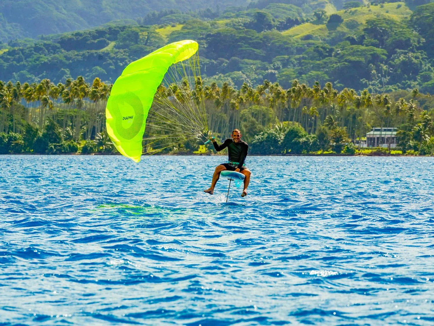 Gong Lowkite rider foiling from overhead drone perspective in tropical blue water