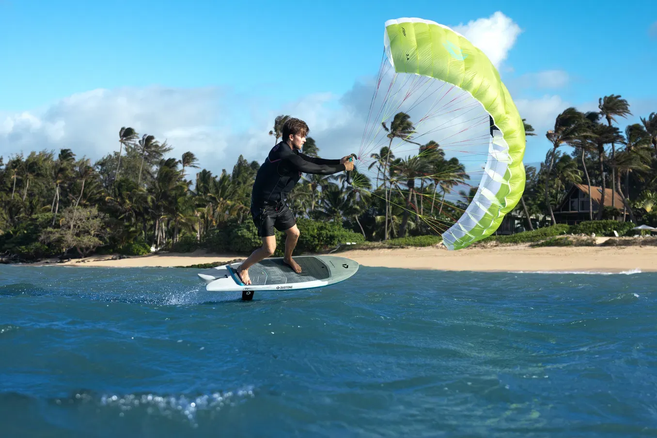 Parawingfoiler riding past palm trees in Maui with a Duotone Stash parawing